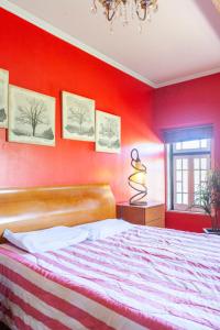 1 dormitorio con pared roja, cama y ventana en B&B Quarto Vermelho Estilo Moderno, 