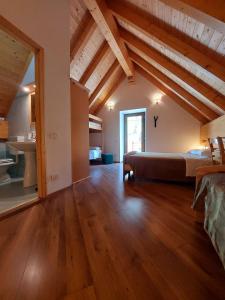 ein Schlafzimmer mit einem Bett in einem Zimmer mit Holzdecken in der Unterkunft Rifugio Fornas in Tolmezzo