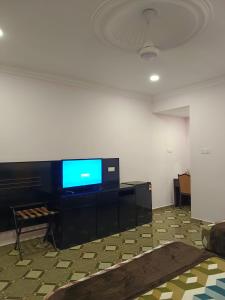 a room with a flat screen tv on a wall at Alfa Roomstay in Pantai Cenang