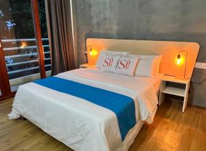 ein Schlafzimmer mit einem Bett mit zwei Kissen darauf in der Unterkunft Si! Beach House in Dhiffushi