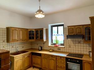 a kitchen with wooden cabinets and a window at Dolina Rastoki in Koniaków