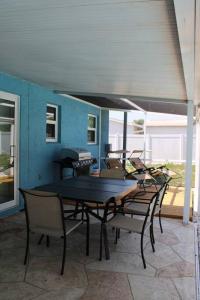 patio ze stołem i krzesłami na ganku w obiekcie Pool house in Port Charlotte w mieście Port Charlotte