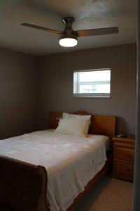 Schlafzimmer mit einem Bett und einem Deckenventilator in der Unterkunft Pool house in Port Charlotte in Port Charlotte