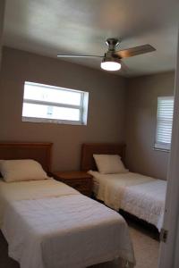 a bedroom with two beds and a ceiling fan at Pool house in Port Charlotte in Port Charlotte