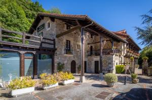 a stone building with plants in front of it at Hotel Spa Casona La Hondonada in Terán