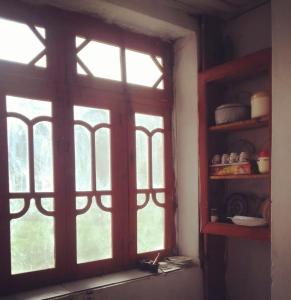 - une fenêtre ouverte dans une chambre avec une étagère dans l'établissement Siwakhat Huts, 