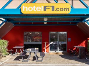 a red building with a hotel london sign on it at hotelF1 Nîmes Ouest in Nîmes