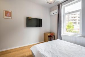 ein Schlafzimmer mit einem Bett und einem TV an der Wand in der Unterkunft Cute central apartments in villa in Bukarest