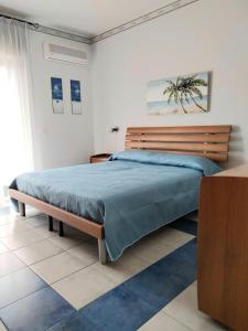 Schlafzimmer mit einem großen Bett mit einem Kopfteil aus Holz in der Unterkunft Blu Corallo in Mascali