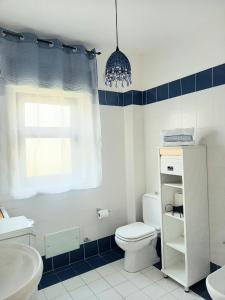 ein Badezimmer mit einem weißen WC und einem Waschbecken in der Unterkunft Blu Corallo in Mascali