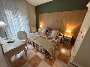 een slaapkamer met een bed, een tafel en een stoel bij Hostal Bonavista in Cervera