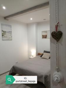 a bedroom with a bed with a heart on the wall at PortStreet apartamenti in Liepāja