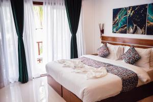 a bedroom with two beds and a large window at Akiri Dhigurah in Dhigurah