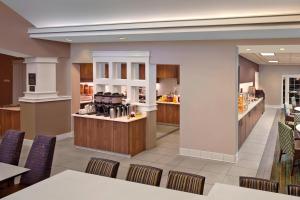a restaurant with a counter and chairs and a kitchen at Residence Inn Hartford Avon in Avon