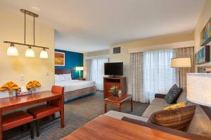 アビリーンにあるResidence Inn by Marriott Abileneのベッドとリビングルームが備わるホテルルームです。