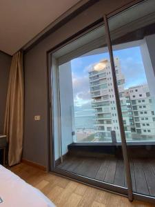 a bedroom with a large window with a view of a city at MARINA APARTMENT OCEAN VIEW in Casablanca