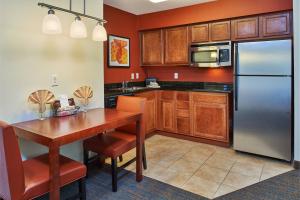 a kitchen with a wooden table and a refrigerator at Residence Inn by Marriott Abilene in Abilene