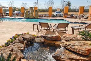 a swimming pool with a fountain in a yard at Residence Inn by Marriott Abilene in Abilene