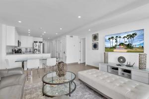 サウス・パドレ・アイランドにあるSpectacular Ocean-View Condo in Beachfront Resortの白いリビングルーム(ソファ、テーブル付)