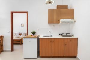 a kitchen with a white refrigerator and a sink at Aphrodite Apartments in Kalyves