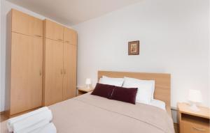 a bedroom with a large bed and wooden cabinets at Awesome Apartment In Krk With 1 Bedrooms And Wifi in Krk