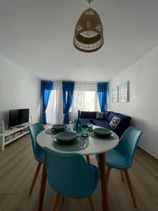 een woonkamer met een tafel en blauwe stoelen bij Blue Ocean in Costa Teguise