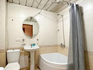 a bathroom with a sink and a toilet and a tub at RIS Central Apartments Yerevan in Yerevan