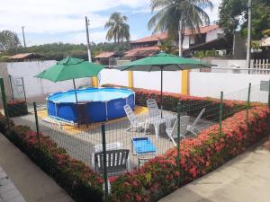 a swimming pool with two umbrellas and a table and chairs at Casa na Praia em Maceió apenas a 120 mts do Mar in Maceió