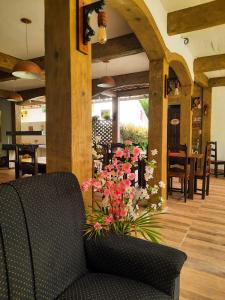 a lobby with a chair and flowers in a room at Hotel Mitologia Algodoal in Algodoal