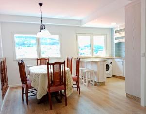 a kitchen and dining room with a table and chairs at Atico en La Ría in Viveiro