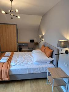 普沃茨克的住宿－Pokoje De Luxe Figaro，一间卧室配有一张大床和一张桌子