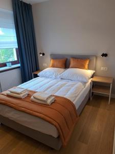 1 dormitorio con 1 cama grande y 2 toallas. en Pokoje De Luxe Figaro, en Płock