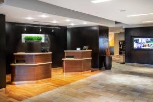 a lobby with a reception desk and a television at Courtyard by Marriott Denton in Denton