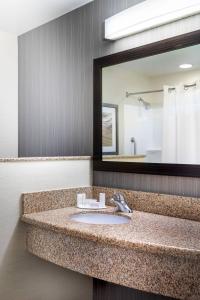 a bathroom with a sink and a large mirror at Courtyard by Marriott Denton in Denton