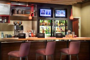 un bar con 2 sillas y una barra con bebidas en Courtyard by Marriott Denton, en Denton