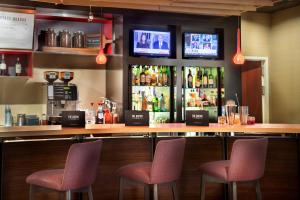a bar with two chairs and a counter with drinks at Courtyard by Marriott Denton in Denton