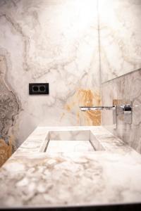 a white marble bathroom with a sink in it at Cosmopolita Boutique Hotel in Timişoara