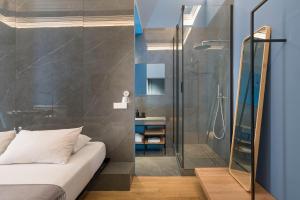 a bathroom with a shower and a bed in a room at FilHome 44 in Catania