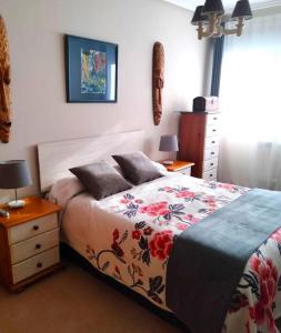 sypialnia z łóżkiem i komodą z 2 lampami w obiekcie Apartamento con jardín Playa Foz w mieście Foz