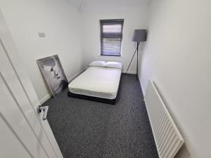 a small room with a bed and a window at Emergency - Bedrooms Only in Birkenhead