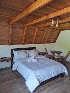 a large white bed in a room with wooden ceilings at Cabañas Amalú in San Agustín