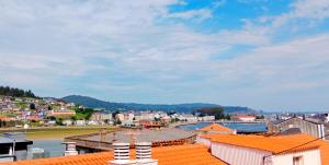 Blick auf eine Stadt mit orangefarbenen Dächern in der Unterkunft Atico en La Ría in Vivero