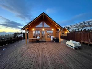 a cabin with a wooden deck with a sunset in the background at LL Properties - Cabin With Amazing View in Akureyri