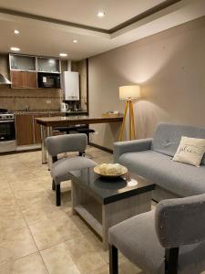 een woonkamer met een bank en een tafel bij Aparts Calafate Suites in El Calafate