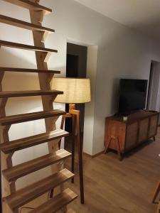 a living room with a wooden staircase and a television at Appartement sur Terrasse in Capbreton