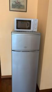 un forno a microonde seduto sopra un frigorifero di Toledo Suite a Napoli