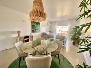 a dining room with a glass table and chairs at Vilamoura Avelãs Ocean View Apartment in Vilamoura