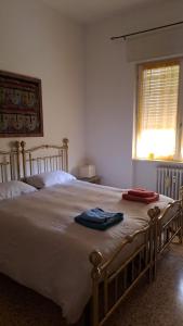 1 dormitorio con 1 cama grande y 2 toallas. en La Casa di Lucia: Grande appartamento con balcone en Brescia