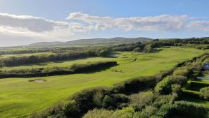an aerial view of a golf course with a green field at Wild Atlantic Way Cabin in Ballyheigue