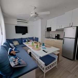 sala de estar con sofá azul y cocina en Suite Brisas Cancun, en Cancún